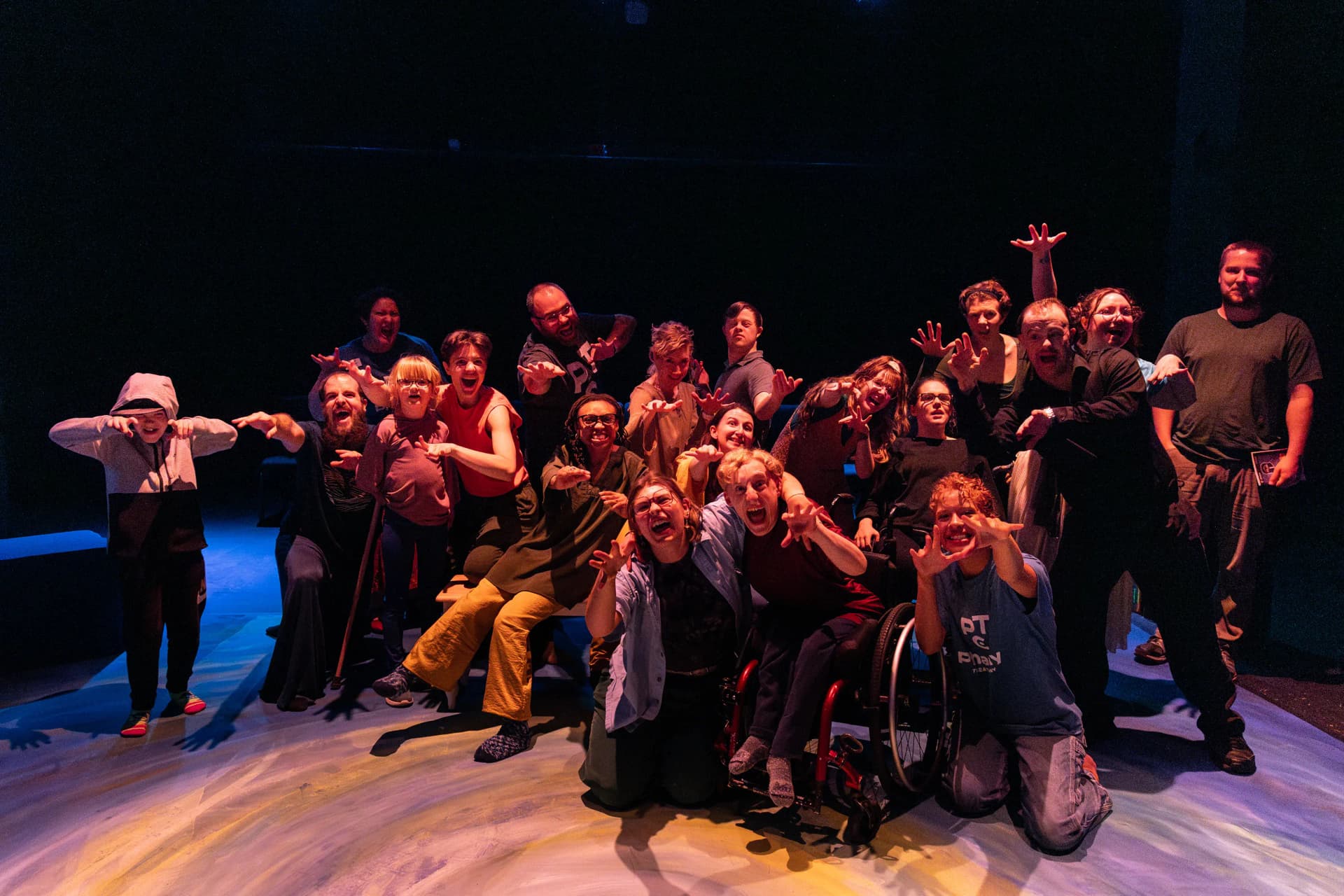 Group photo of actors and participants in Denver during a Flute Theatre production of Pericles, showcasing an inclusive performance with energetic expressions and diverse performers.