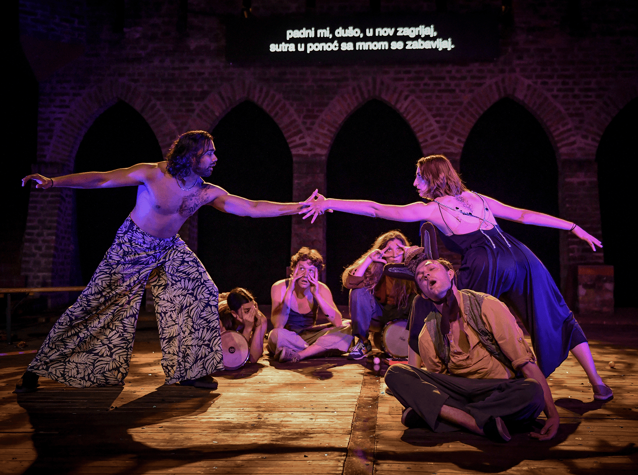 A scene from a Flute Theatre adaptation of A Midsummer Night’s Dream. Actors stretch dramatically across a stage, surrounded by music and playful physical storytelling. The production merges Shakespeare’s words with accessible performance for autistic audiences and mixed-ability casts.