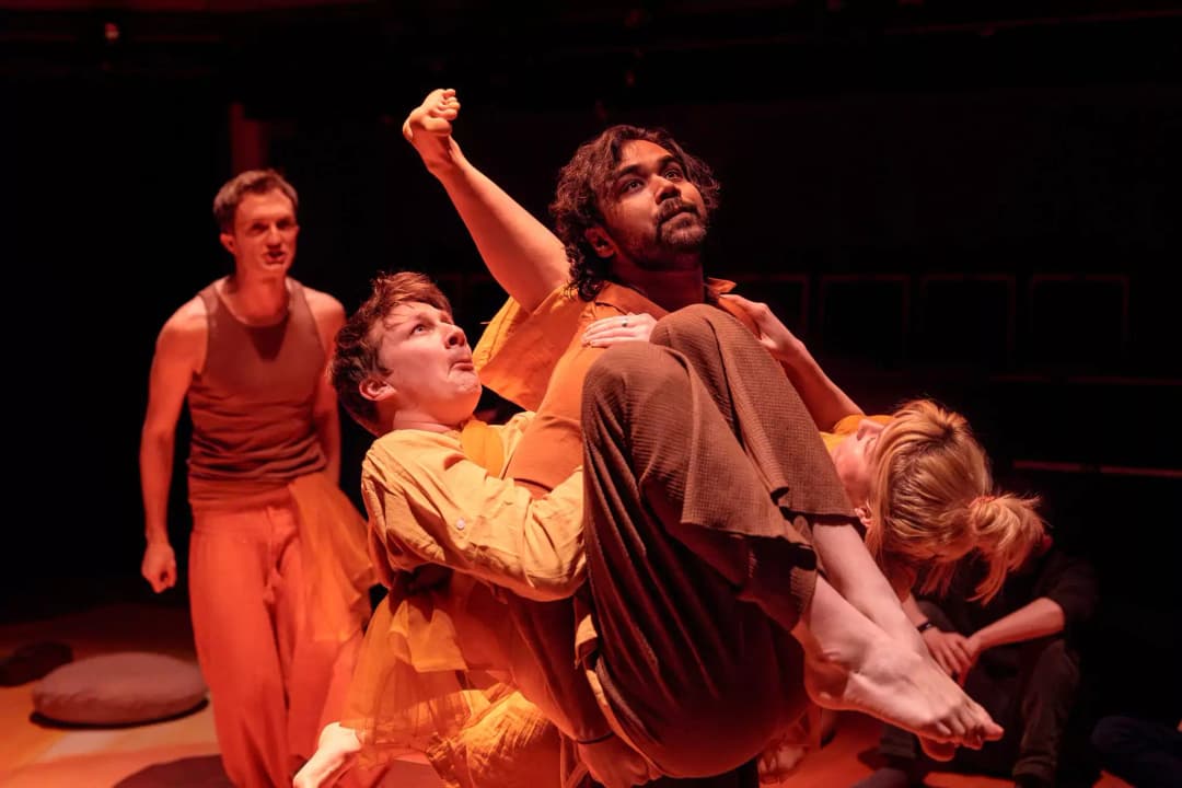 Actors from Flute Theatre’s Twelfth Night hold one another in a dramatic and expressive lift, using the Hunter Heartbeat Method to communicate emotion through movement for autistic participants.