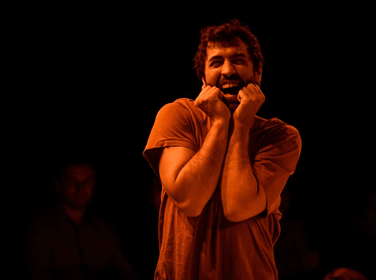 Actors dressed in red move dynamically across the floor in a warm, immersive space, surrounded by an audience. This performance by Flute Theatre uses sensory-rich design and movement to make Shakespeare’s language accessible and inclusive.