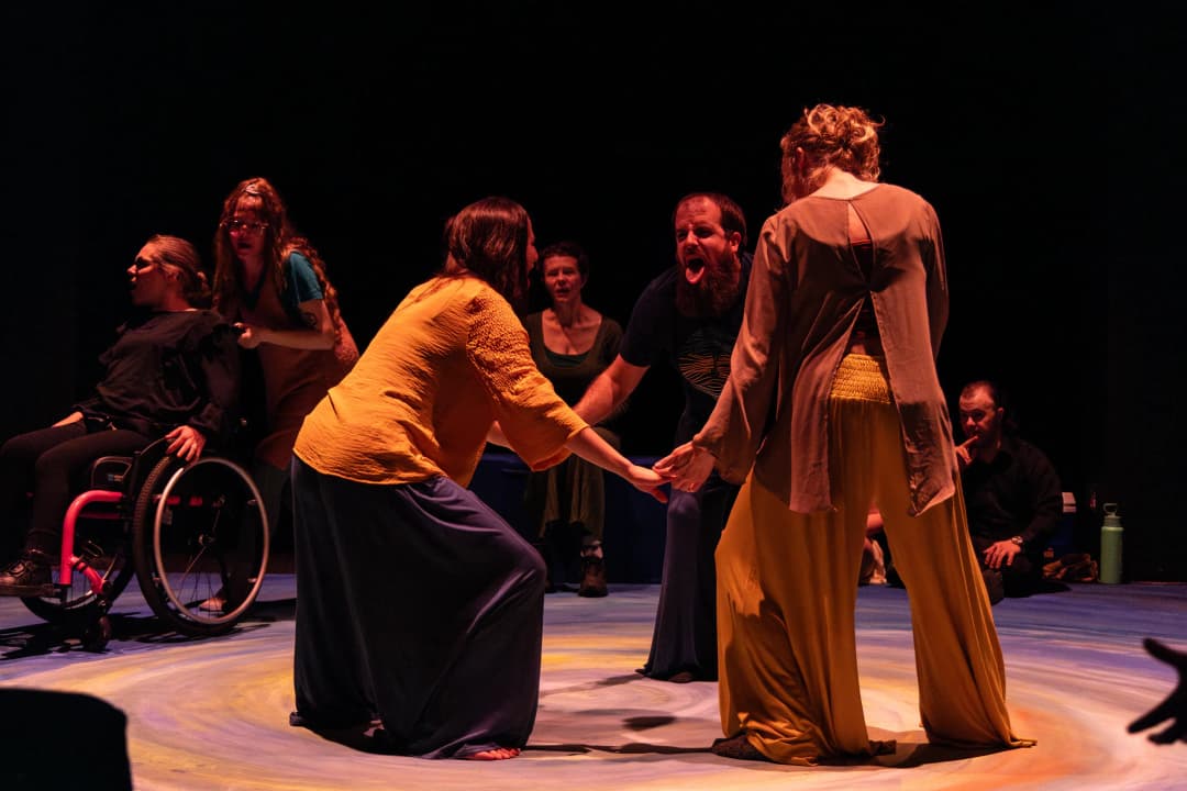 Scene from Pericles in Denver by Flute Theatre, with performers holding hands in an intense moment of storytelling, featuring inclusive theatre practices.